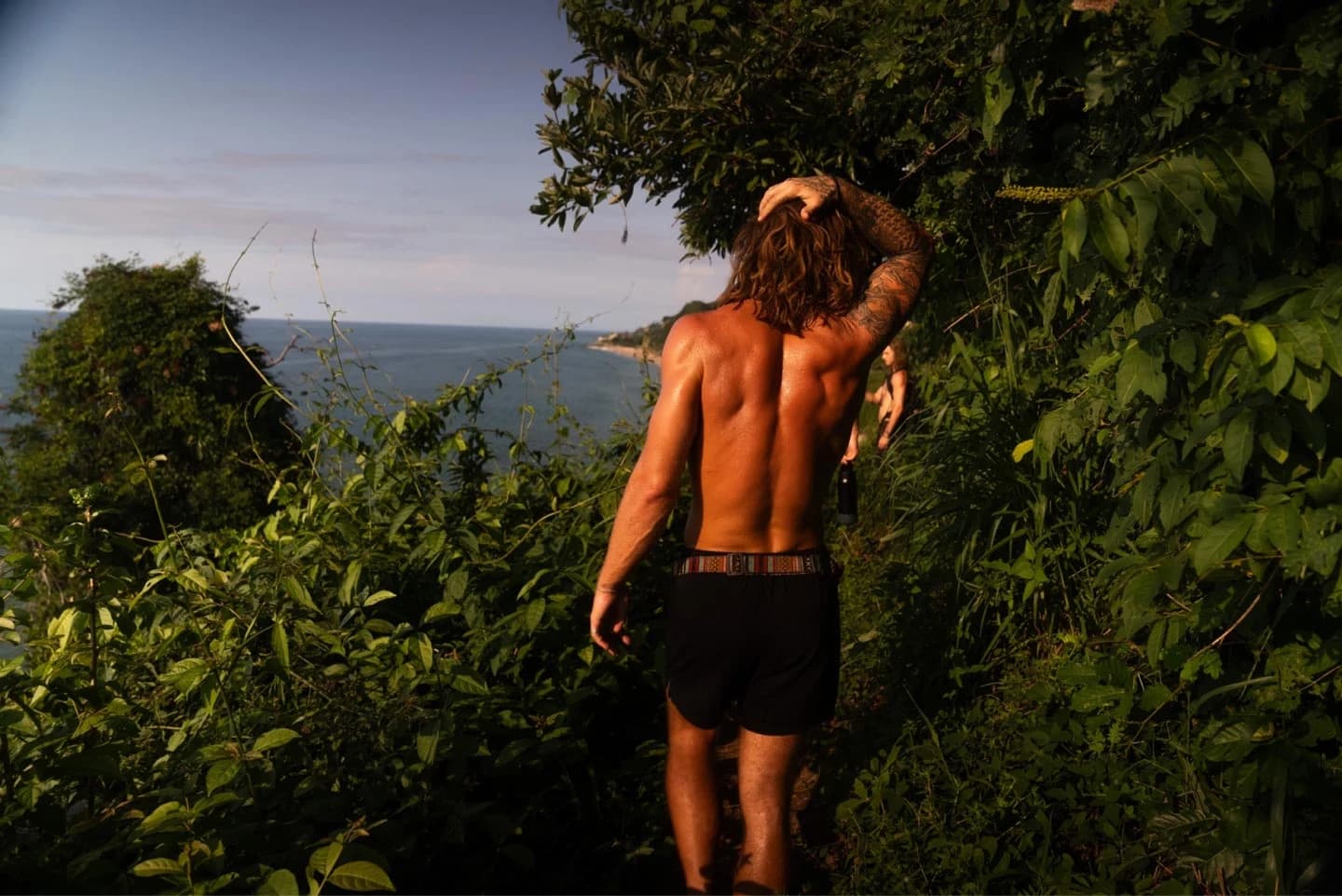 A Bioculture guest walking along a tropical coastal path