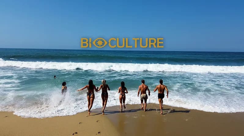 Bioculture guests on a beach beneath the Bioculture wordmark
