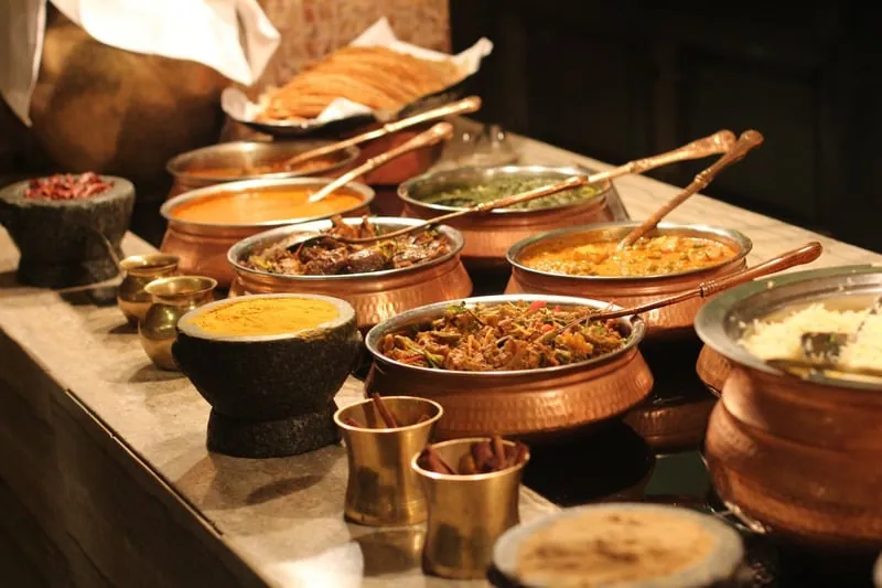 Bowls of warm, spiced dishes laid out on a buffet