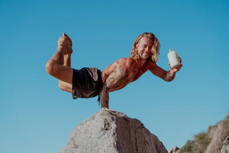 Dakota Mays balancing in a handstand on a rock under a blue sky