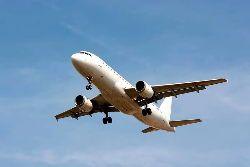 A passenger plane climbing into a blue sky