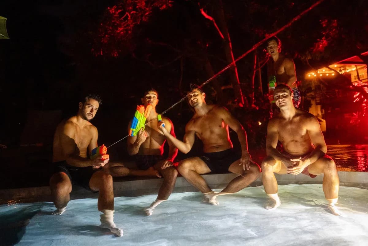 Retreat guests gathered around cold plunge tubs under red light