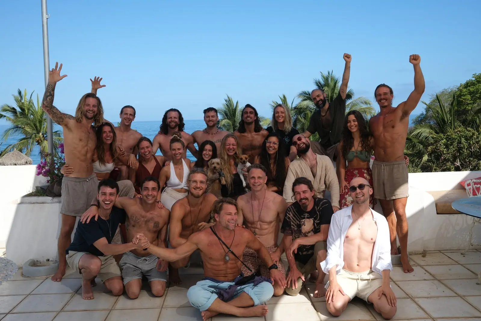 A large retreat group celebrating together on a seaside terrace