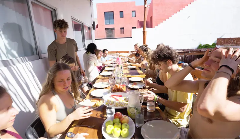 Guests gathered along a long communal dining table
