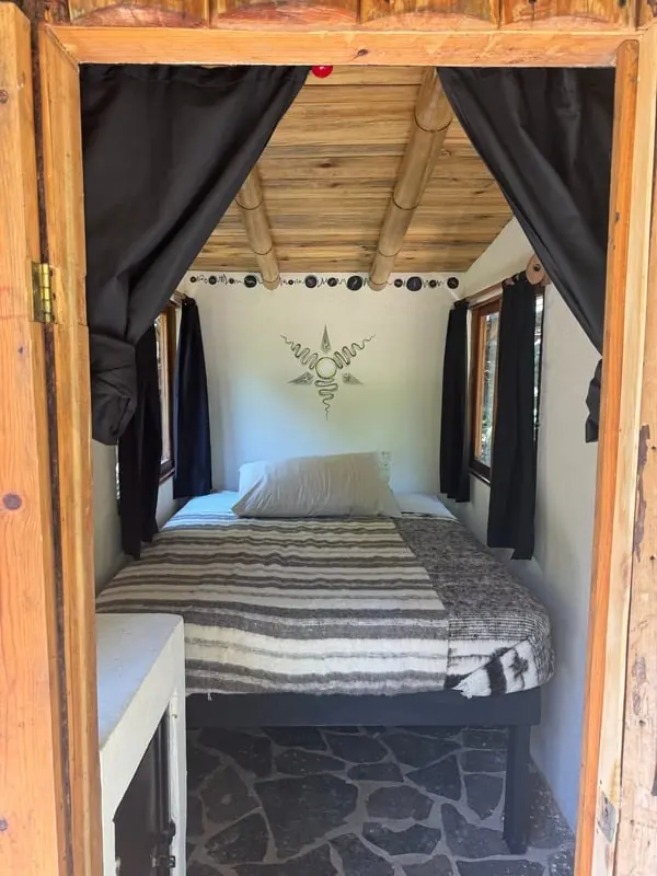 Private cabin bed framed by a wooden doorway