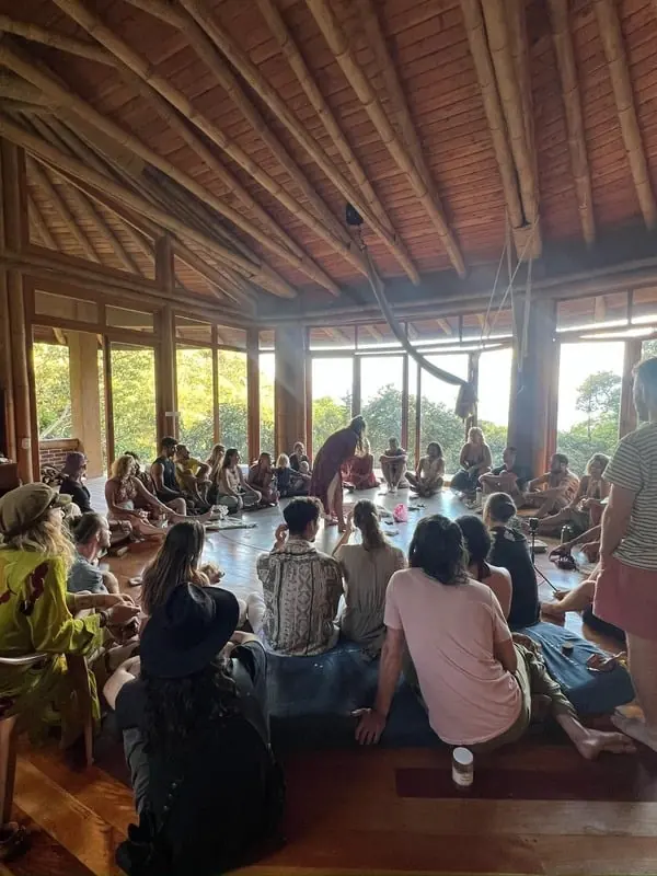 Guests seated across a large wooden shala during a workshop