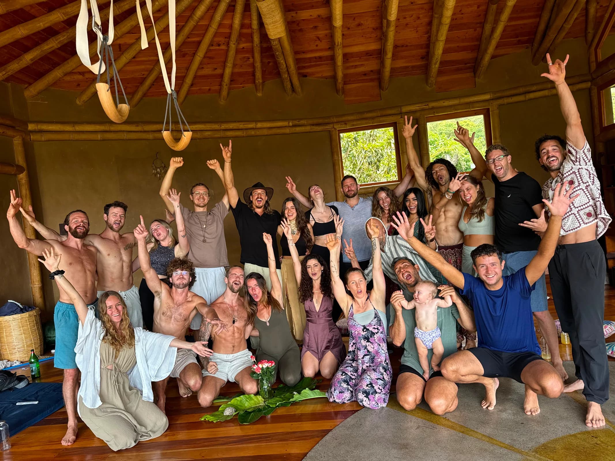 A large Bioculture retreat group smiling together inside a timber gathering space
