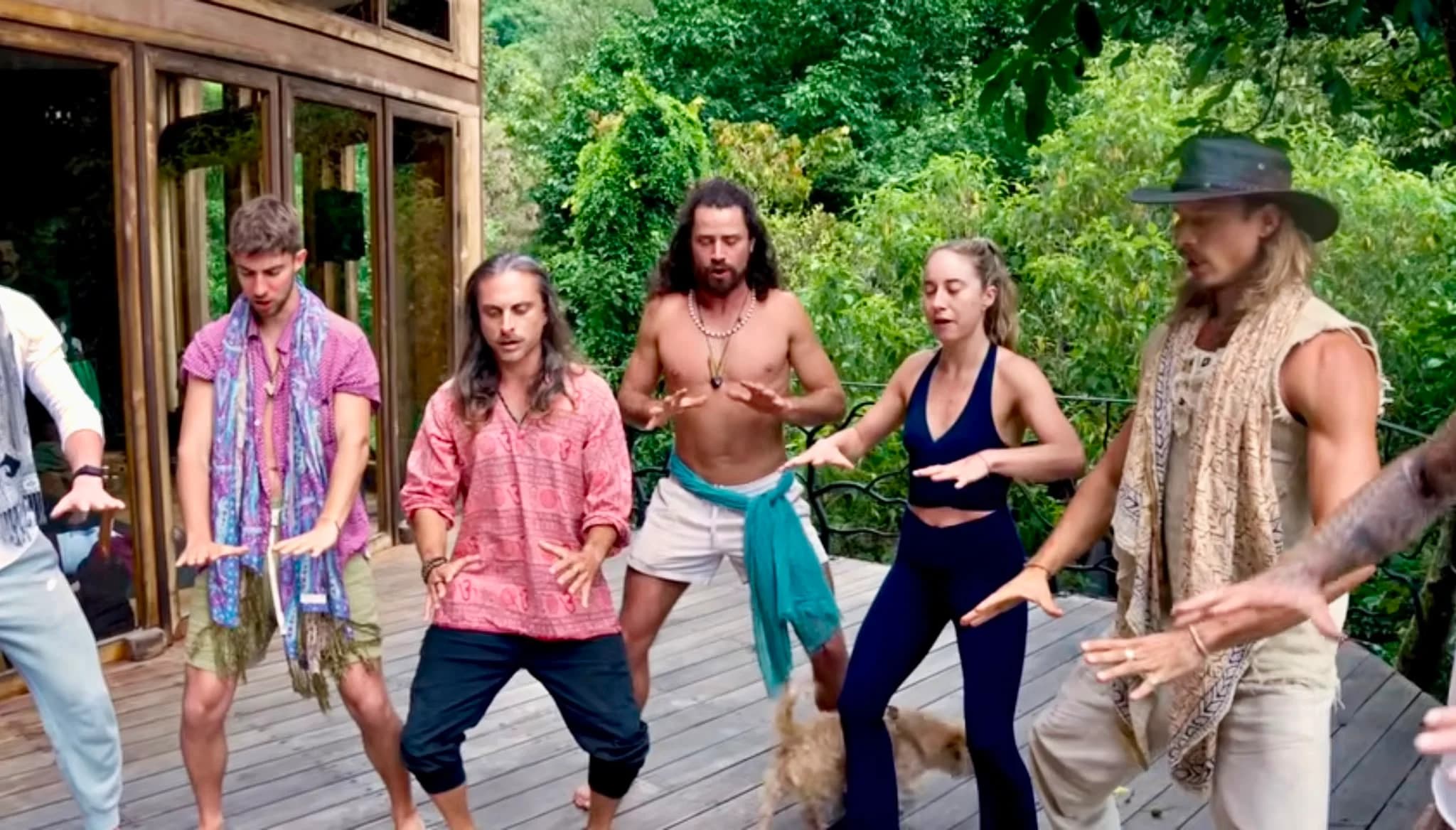 Retreat participants practicing primal movement together on a jungle deck