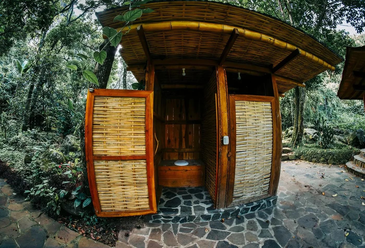 A bamboo garden bathroom with woven doors, among the trees
