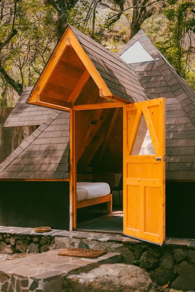The open orange door of the pyramid, with a twin bed visible inside