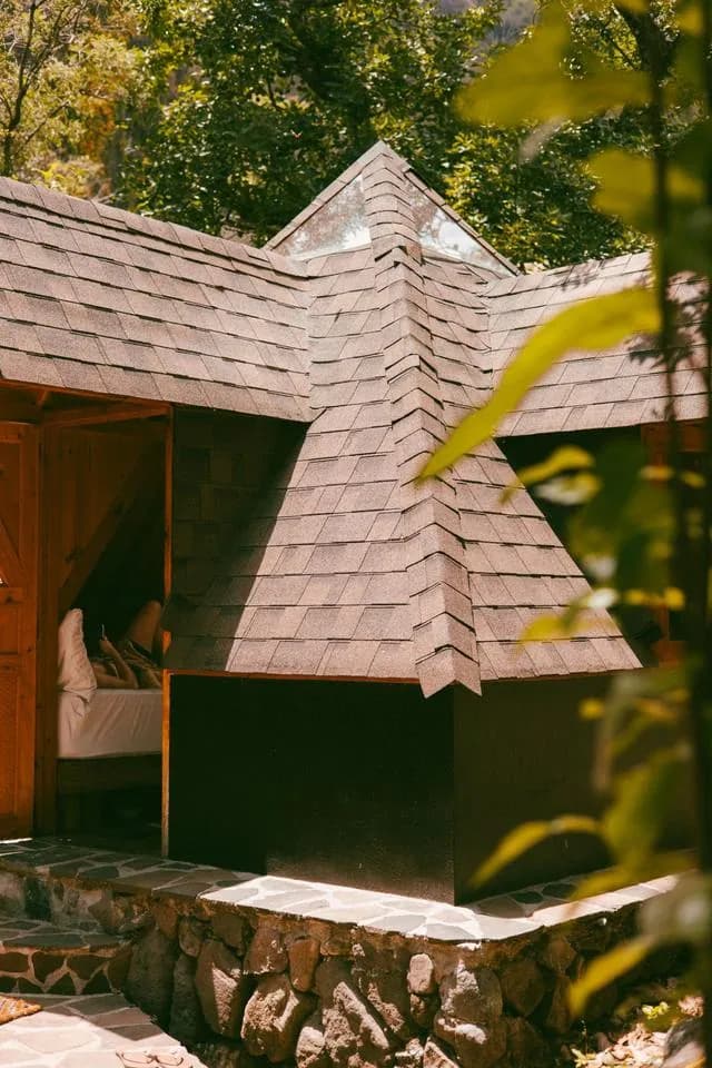 The shingled pyramid roof among the trees