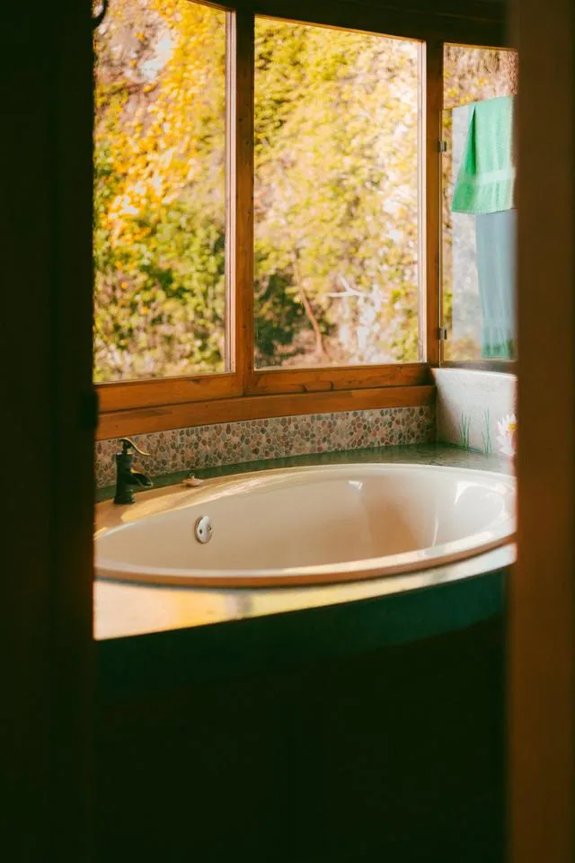 A round tub by a window looking onto the trees