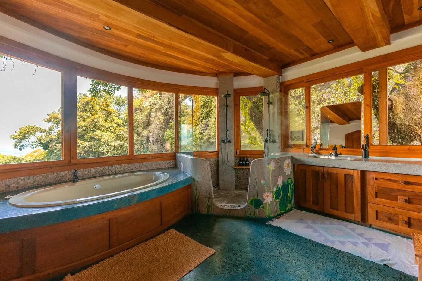 A wide bathroom with a round tub, wood cabinets and big windows