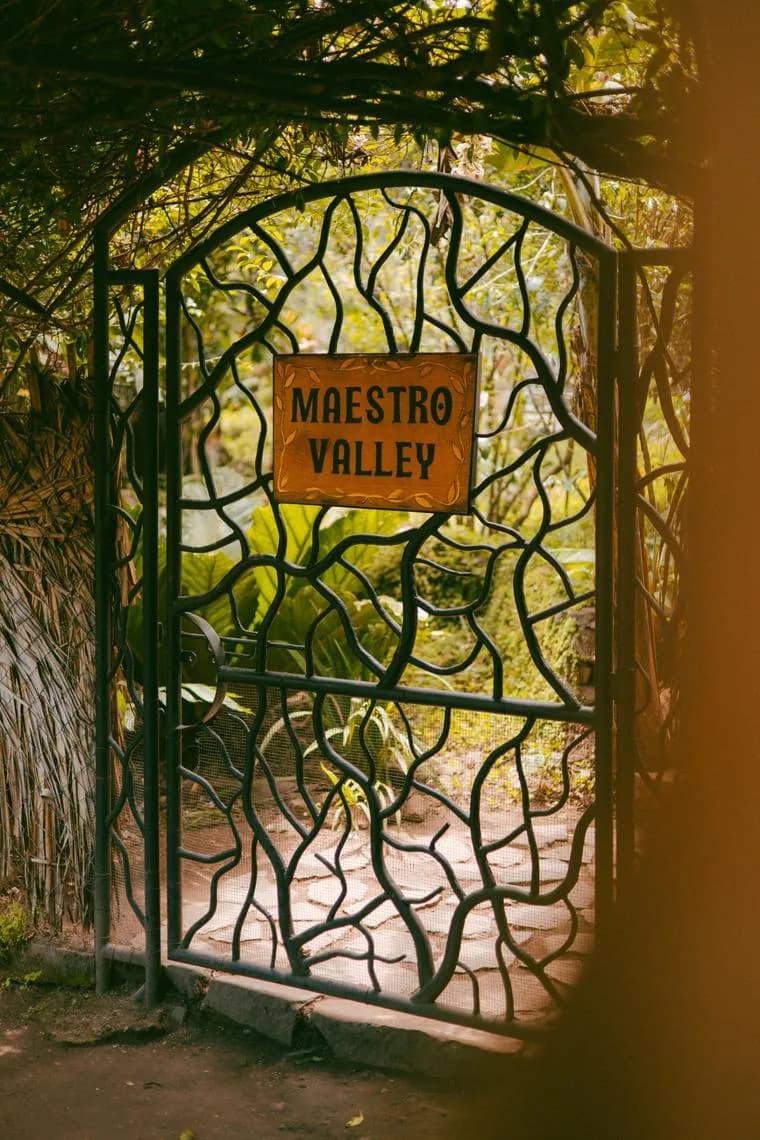The wrought-iron Maestro Valley gate, shaped like branches, with a hand-painted sign