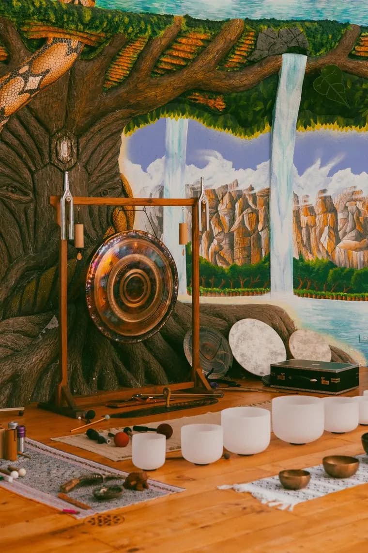 The sound dome with a tree and waterfall mural, a large gong and rows of crystal singing bowls