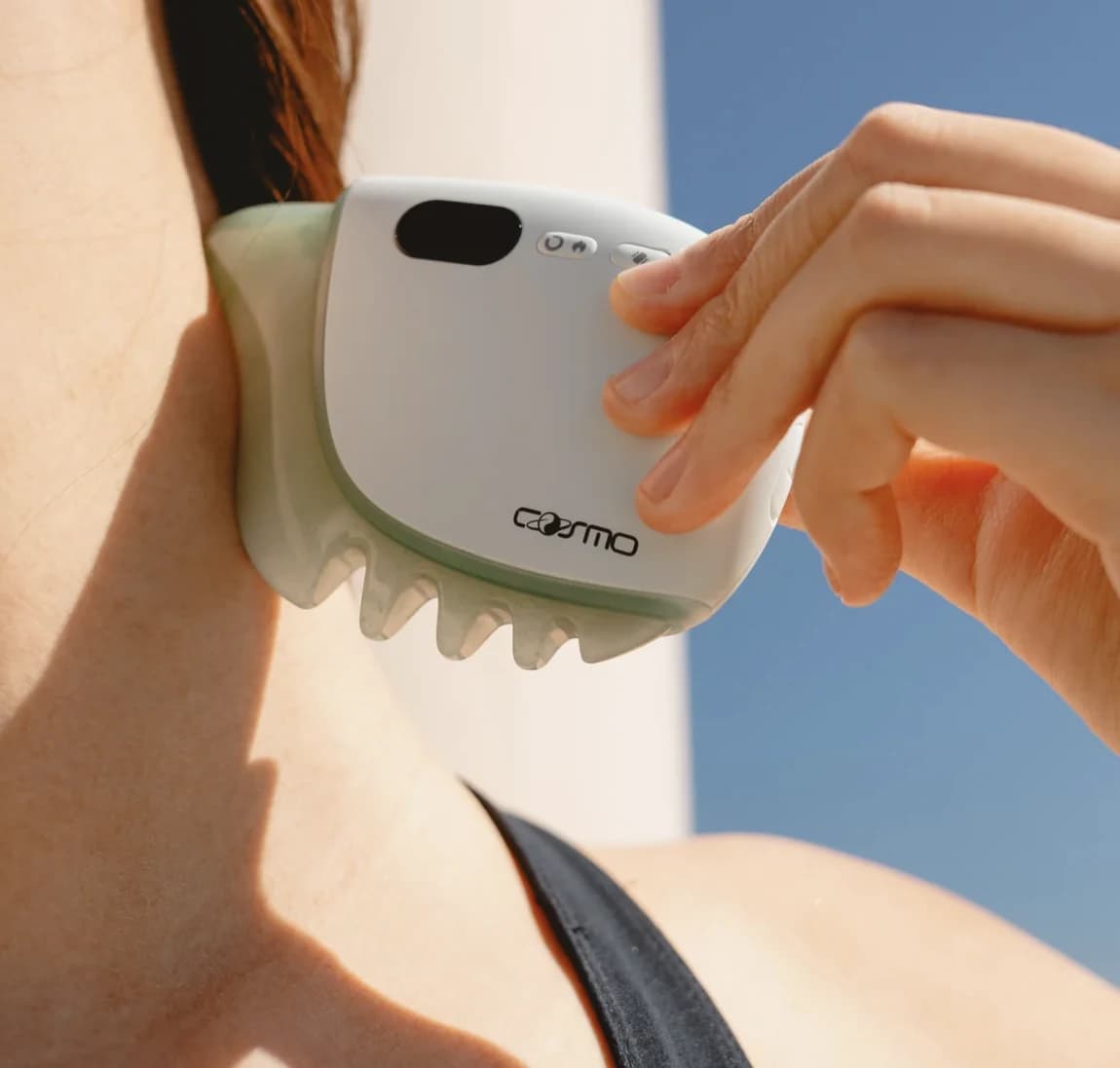A person using a Cosmo handheld care device on their arm