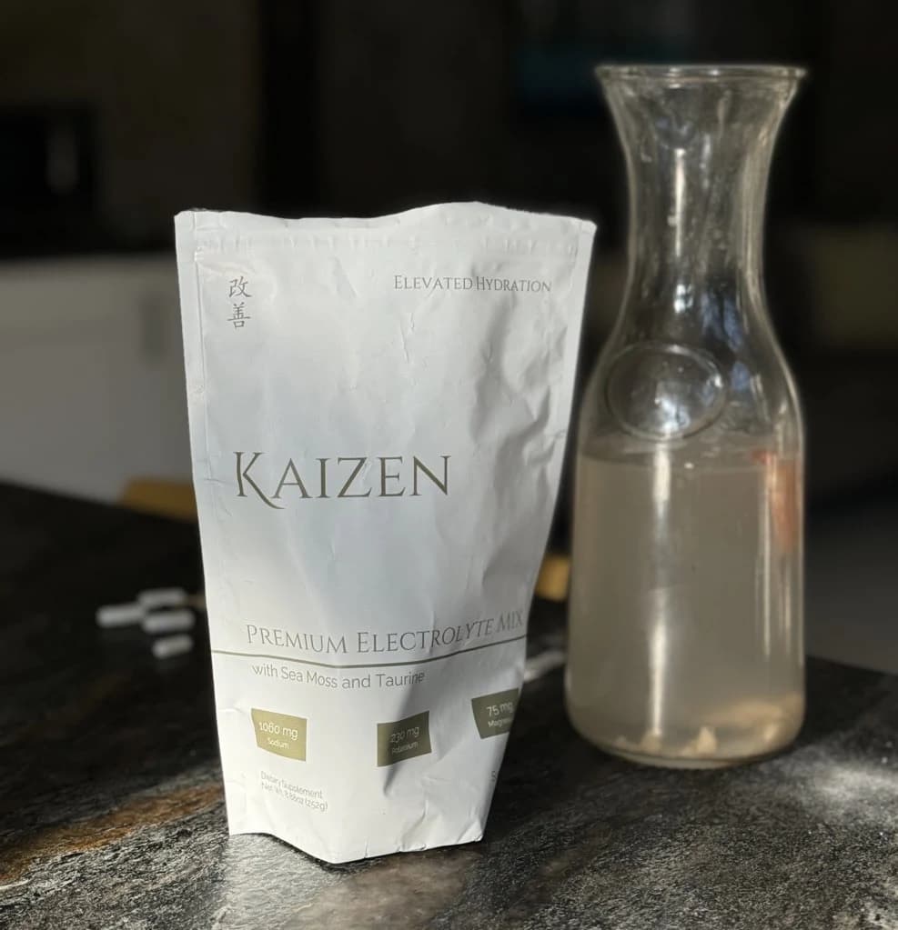 Kaizen hydration pouch and glass on a table
