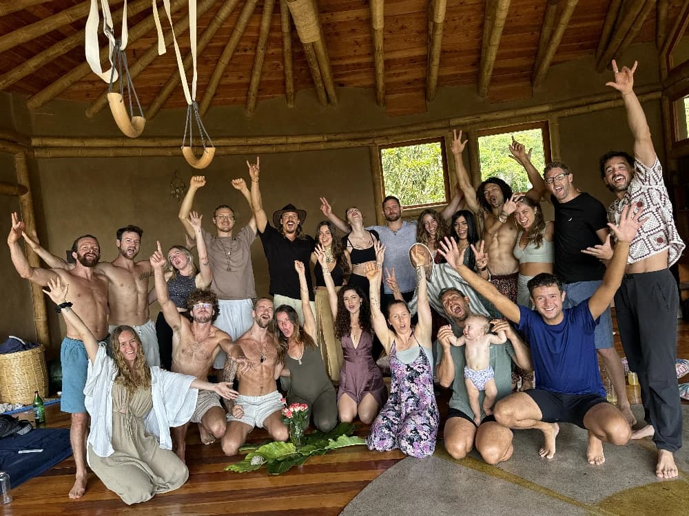 Retreat guests celebrating together inside a warm timber gathering space at Maestro Valley